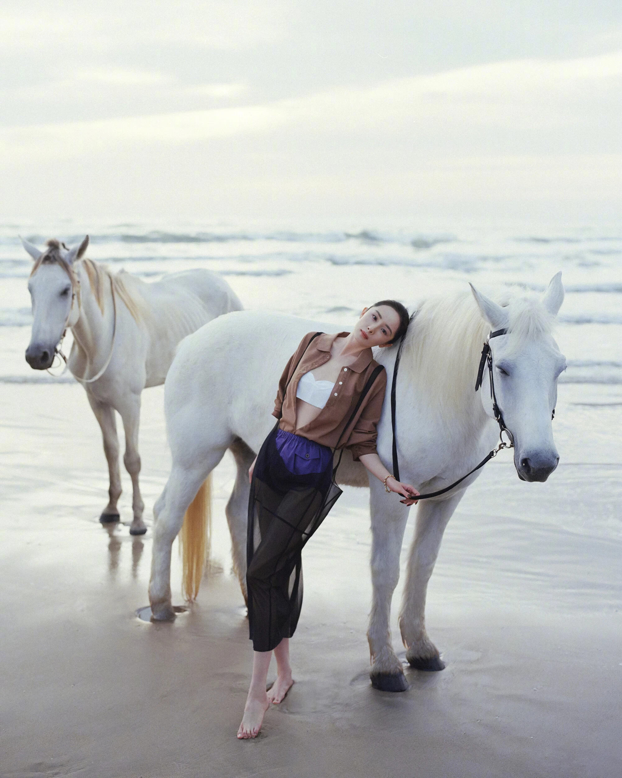 Yang Mi wearing a brown shirt, white bandeau top, and violet shorts for Vogue China