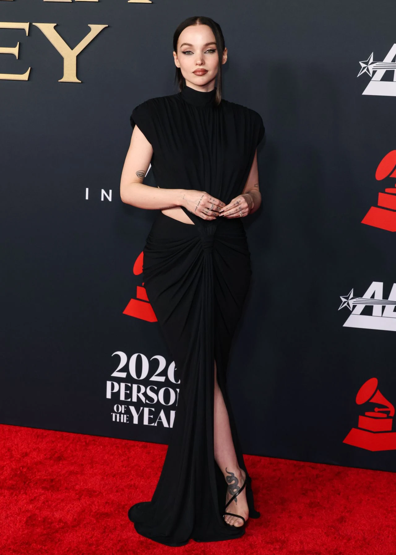 Dove Cameron styling black gown with slicked-back hair