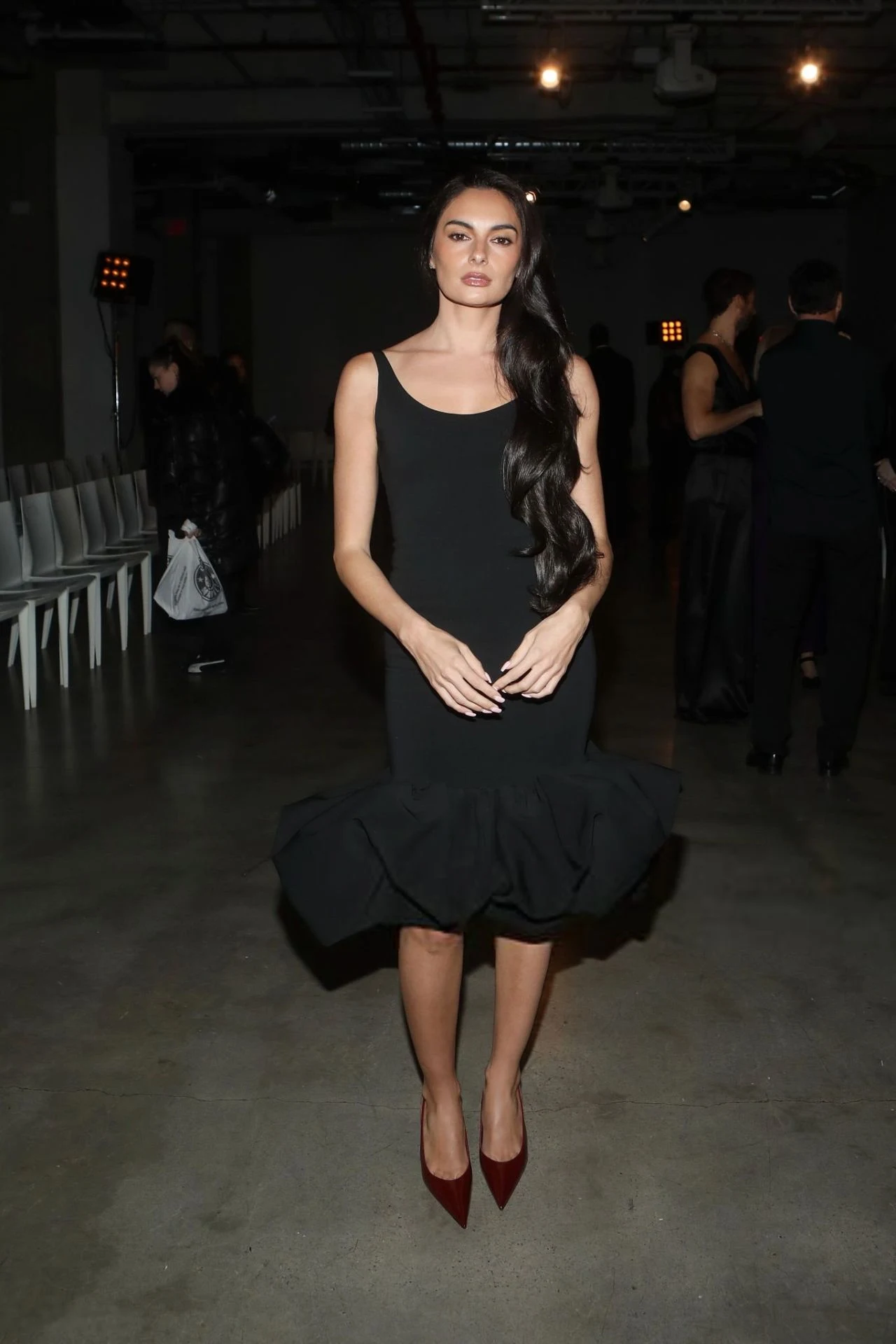 Paige DeSorbo in fitted black dress with sculptural hem