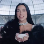Dua Lipa wearing black fur coat inside Milan’s Galleria for NBC Olympics promo